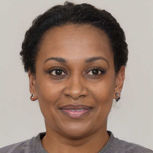 Joyful black adult female with short  black hair and brown eyes