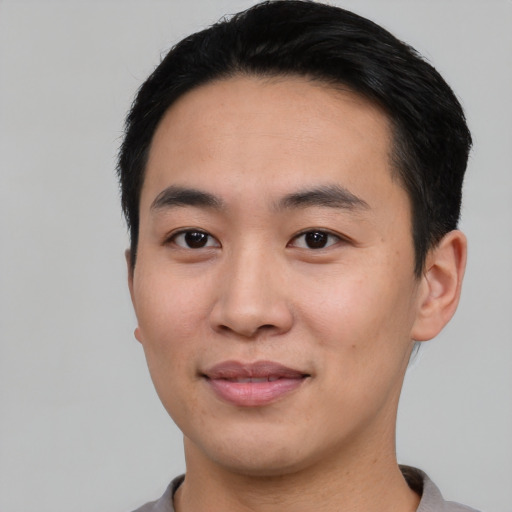 Joyful asian young-adult male with short  black hair and brown eyes