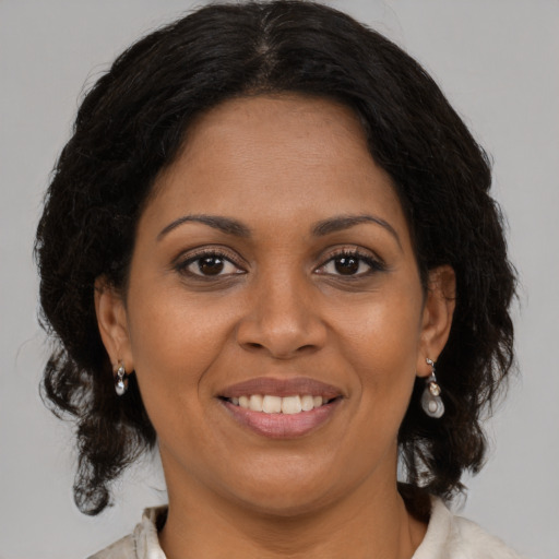 Joyful black adult female with medium  brown hair and brown eyes