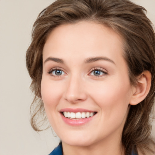 Joyful white young-adult female with medium  brown hair and green eyes