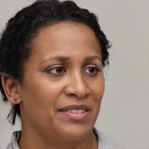 Joyful black adult female with medium  brown hair and brown eyes