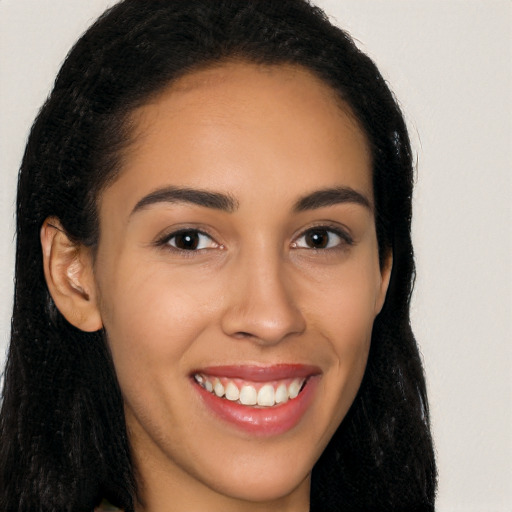 Joyful latino young-adult female with long  brown hair and brown eyes