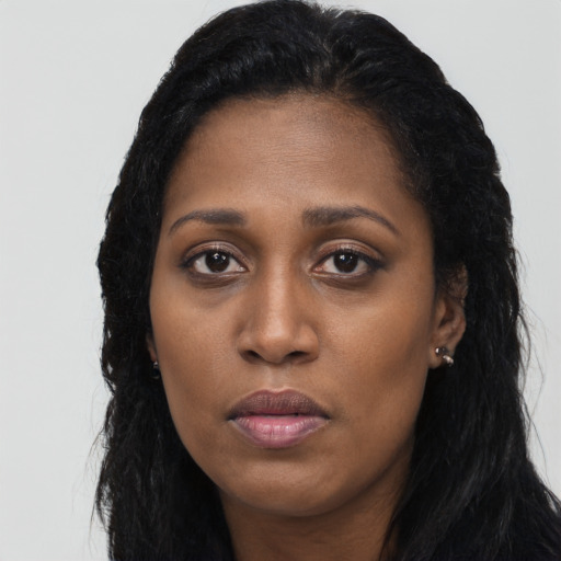 Joyful black young-adult female with long  black hair and brown eyes