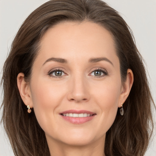 Joyful white young-adult female with long  brown hair and grey eyes