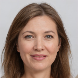 Joyful white adult female with long  brown hair and grey eyes