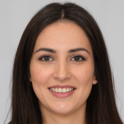 Joyful white young-adult female with long  brown hair and brown eyes