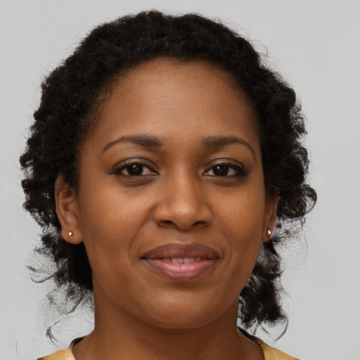 Joyful black adult female with medium  brown hair and brown eyes