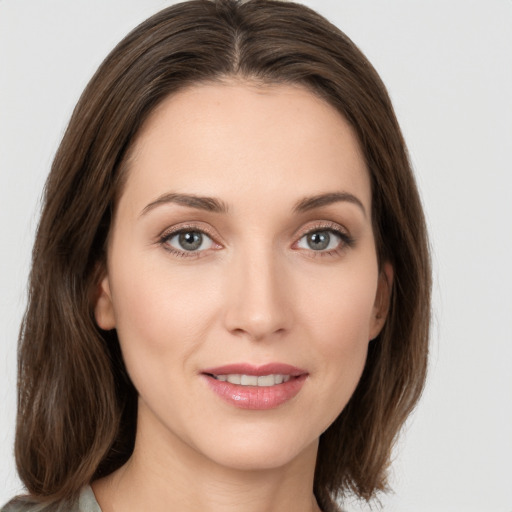 Joyful white young-adult female with long  brown hair and green eyes