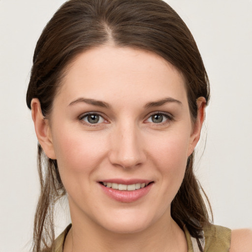 Joyful white young-adult female with medium  brown hair and grey eyes