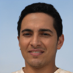 Joyful latino young-adult male with short  brown hair and brown eyes