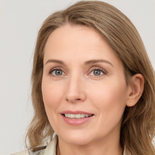 Joyful white adult female with long  brown hair and blue eyes