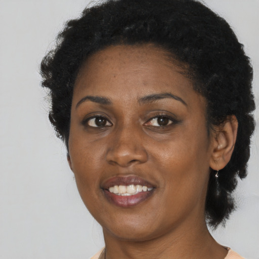 Joyful black young-adult female with short  black hair and brown eyes