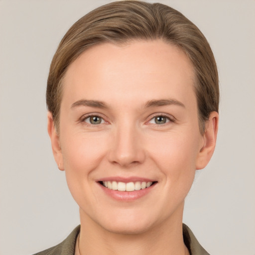 Joyful white young-adult female with short  brown hair and grey eyes