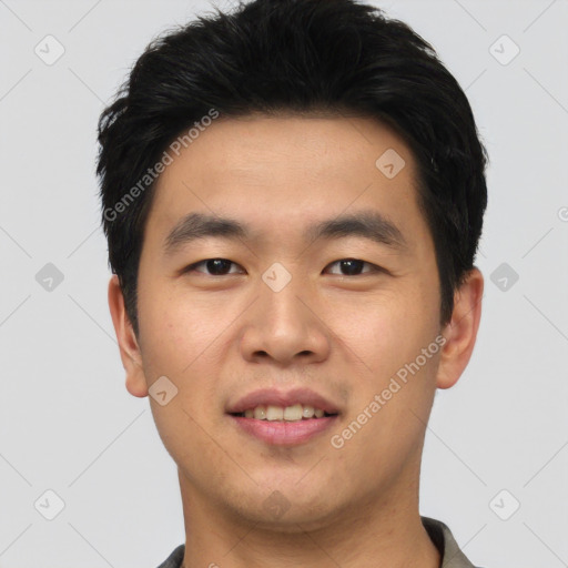 Joyful asian young-adult male with short  black hair and brown eyes