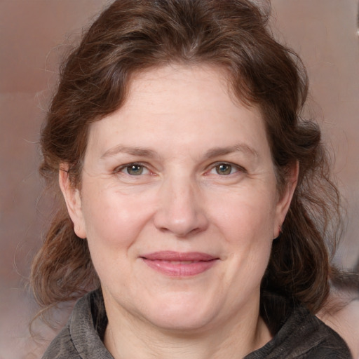 Joyful white adult female with medium  brown hair and blue eyes