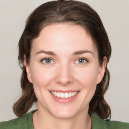 Joyful white young-adult female with medium  brown hair and green eyes