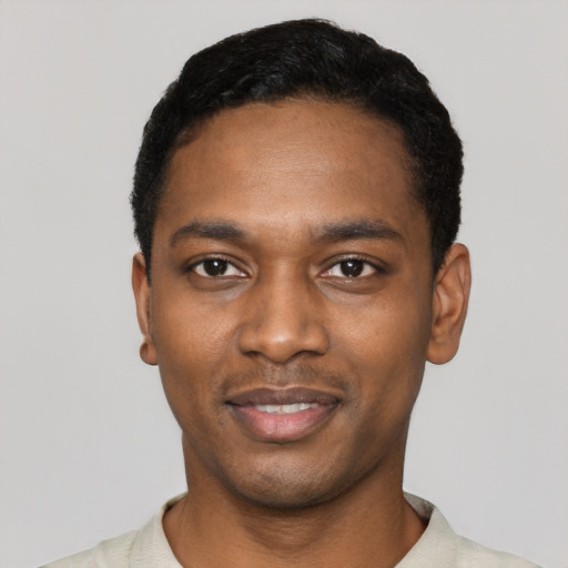 Joyful black young-adult male with short  black hair and brown eyes