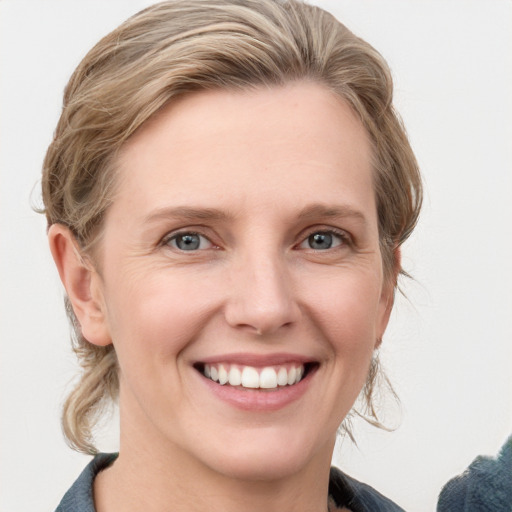 Joyful white young-adult female with medium  brown hair and blue eyes