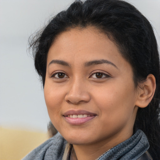 Joyful latino young-adult female with long  brown hair and brown eyes