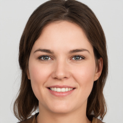 Joyful white young-adult female with medium  brown hair and grey eyes