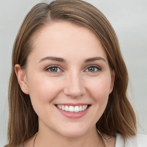 Joyful white young-adult female with long  brown hair and grey eyes