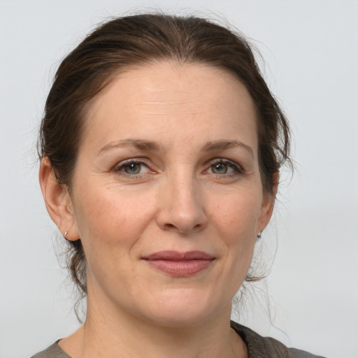 Joyful white adult female with medium  brown hair and grey eyes