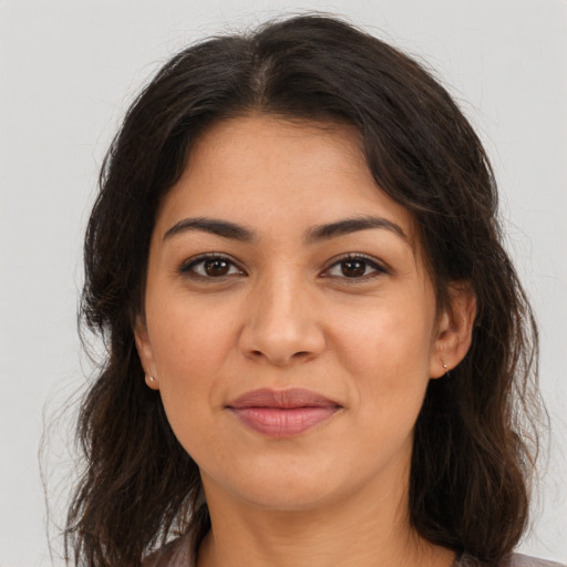 Joyful latino young-adult female with long  brown hair and brown eyes