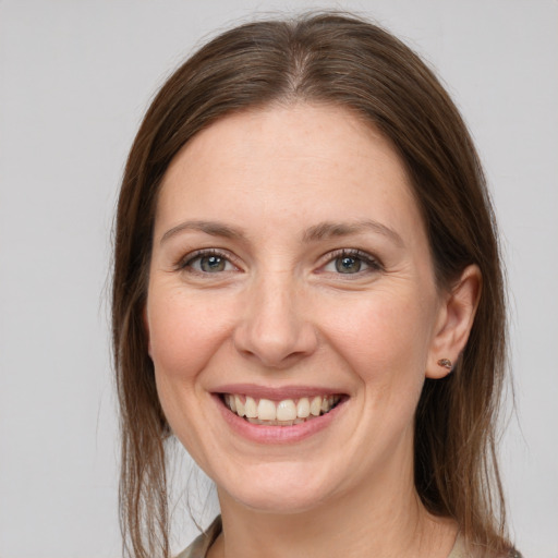 Joyful white young-adult female with long  brown hair and grey eyes