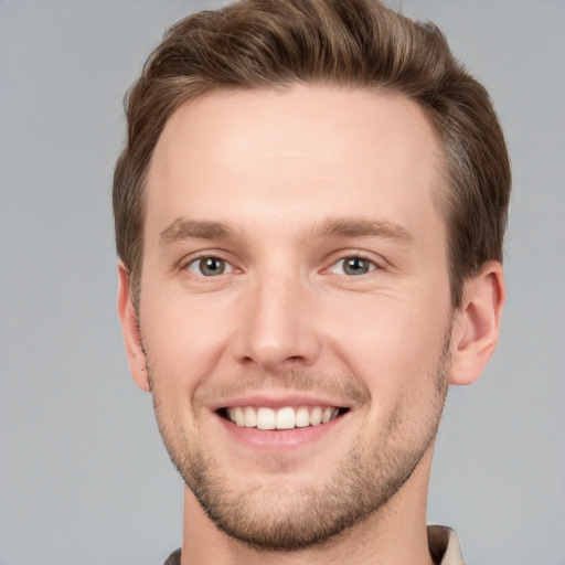 Joyful white young-adult male with short  brown hair and grey eyes