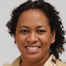 Joyful black adult female with medium  brown hair and brown eyes