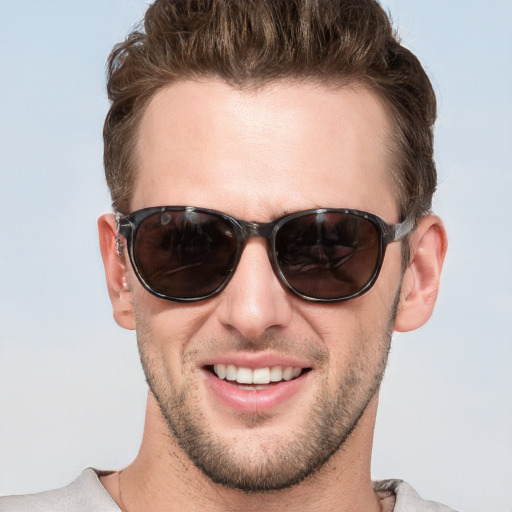 Joyful white young-adult male with short  brown hair and blue eyes