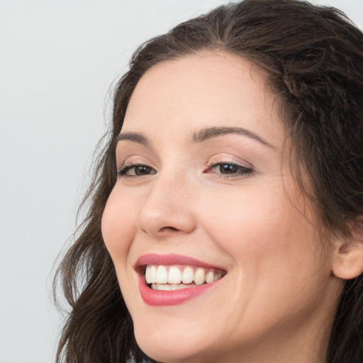 Joyful white young-adult female with long  brown hair and brown eyes