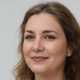 Joyful white adult female with long  brown hair and brown eyes