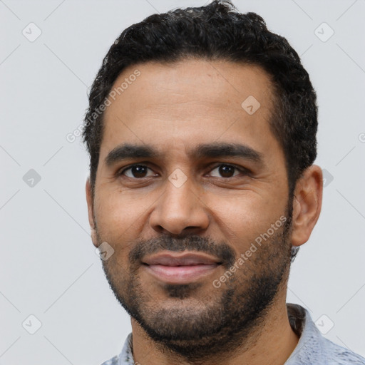 Joyful black young-adult male with short  black hair and brown eyes