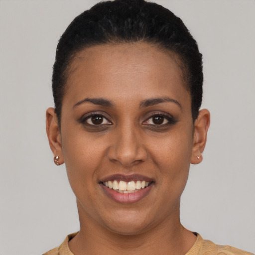 Joyful black young-adult female with short  black hair and brown eyes