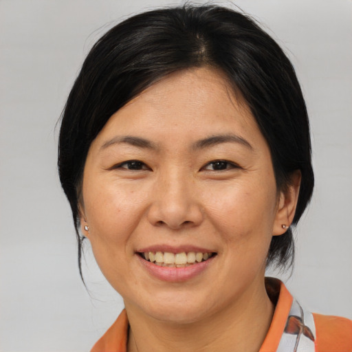 Joyful asian adult female with medium  brown hair and brown eyes