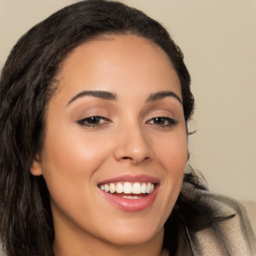 Joyful latino young-adult female with long  brown hair and brown eyes