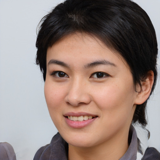 Joyful asian young-adult female with medium  brown hair and brown eyes