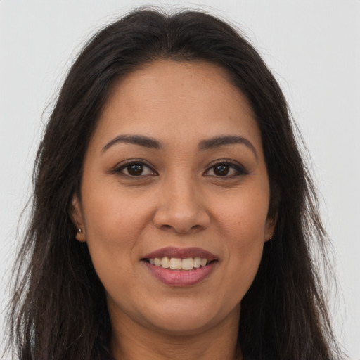 Joyful latino young-adult female with long  brown hair and brown eyes