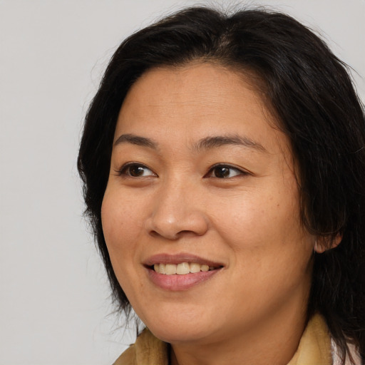 Joyful asian adult female with long  brown hair and brown eyes