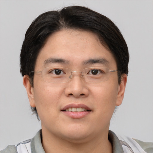 Joyful asian young-adult male with short  brown hair and brown eyes