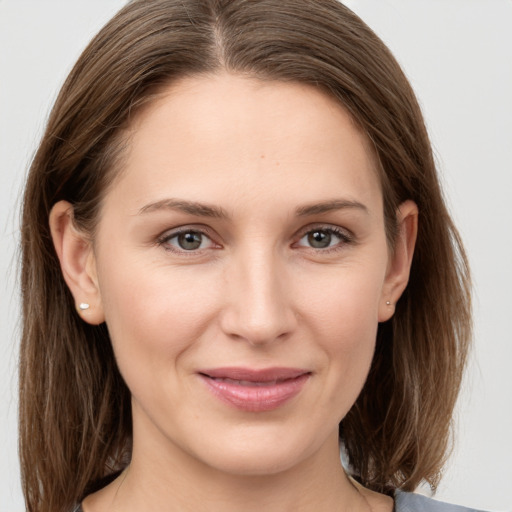 Joyful white young-adult female with medium  brown hair and grey eyes