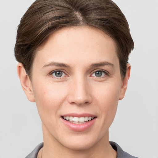 Joyful white young-adult female with short  brown hair and grey eyes