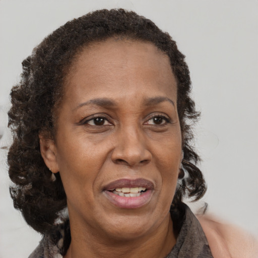 Joyful black adult female with medium  brown hair and brown eyes