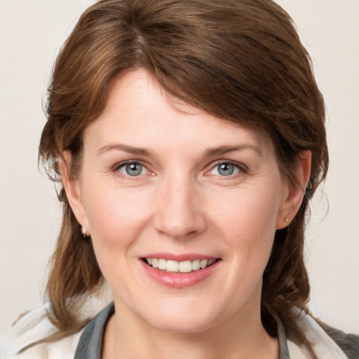 Joyful white young-adult female with medium  brown hair and grey eyes