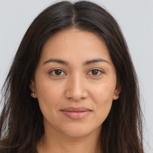 Joyful latino young-adult female with long  brown hair and brown eyes