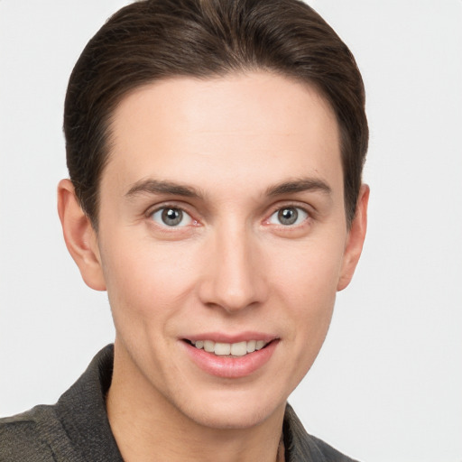 Joyful white young-adult male with short  brown hair and grey eyes