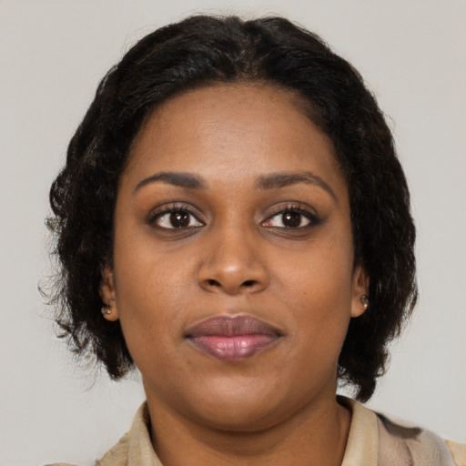 Joyful black young-adult female with medium  brown hair and brown eyes