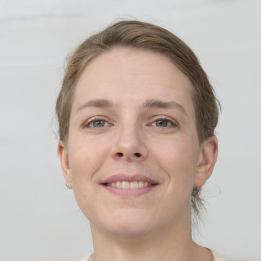 Joyful white young-adult female with short  brown hair and grey eyes