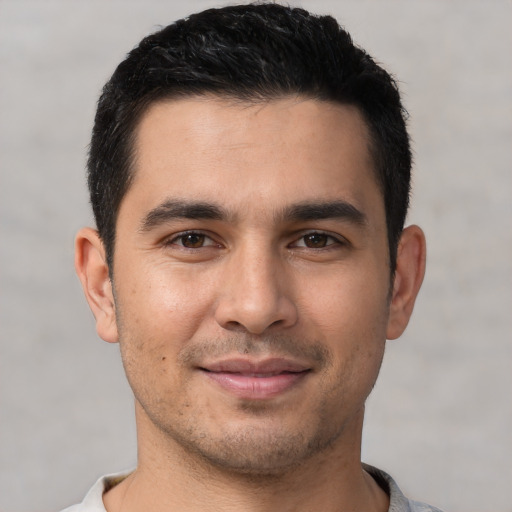 Joyful white young-adult male with short  black hair and brown eyes